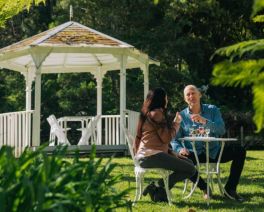 Couple sitting in the garden at Firescreek Botanical Winery, Holgate, Central Coast, NSW